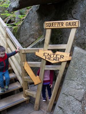 A wood sign marks the narrow passage visitors must fit through for the Lemon Squeezer cave.