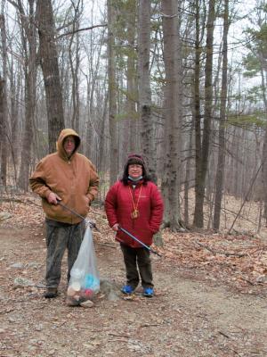 Parents hold a trash bag along the trail at Mount Major.