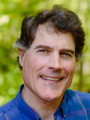 Tom Howe poses in the forest outside of the Conservation Center.