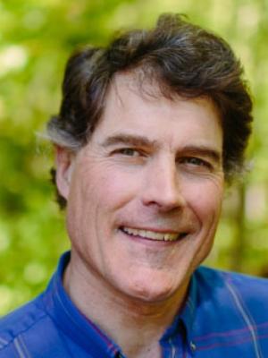 Tom Howe poses in the forest outside of the Conservation Center.