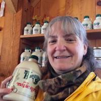 Kate Wilcox holds a bottle of maple syrup.