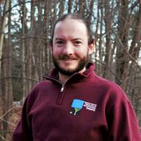 Dylan Summers poses outside on the Conservation Center deck in winter.