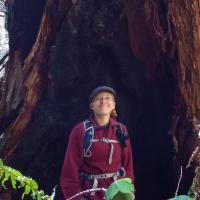 Meghan poses in front of a tree.