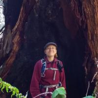 Meghan poses in front of a tree.