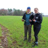 volunteers using compass and map in field smiling