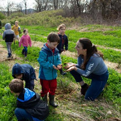 Scarlett Moberly helps a child plant a Christmas tree seedling.
