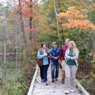 Jessica Hunt, Chris Martin, Dave Anderson and their guests walk on the board walk.