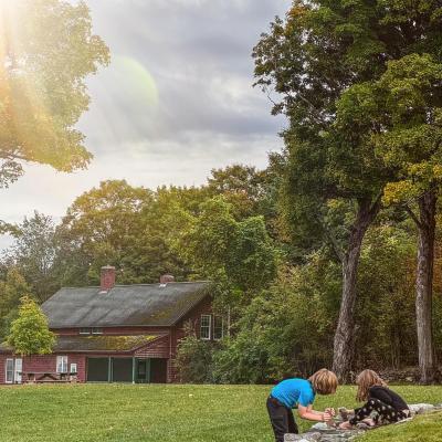 Children play in front of the cottage in fall.