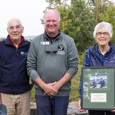 Tim and Midge Eliassen pose with their award with Christmas tree fields in the background.