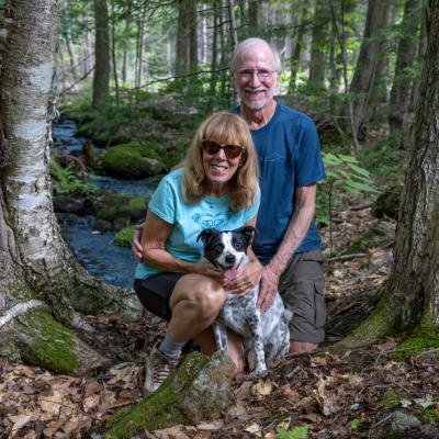 Ken and Ilene Stern pose with their dog in the forest.
