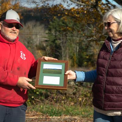 Robert and Sherri Morrill hold a plaque between them during the closing ceremony at the farm.