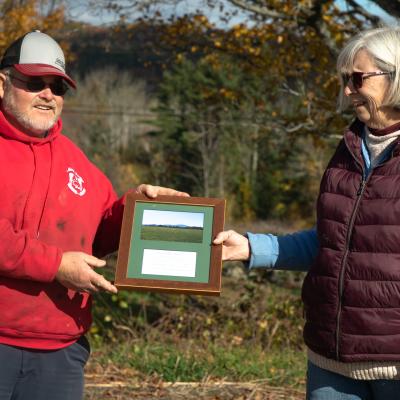 Robert and Sherri Morrill hold a plaque between them during the closing ceremony at the farm.