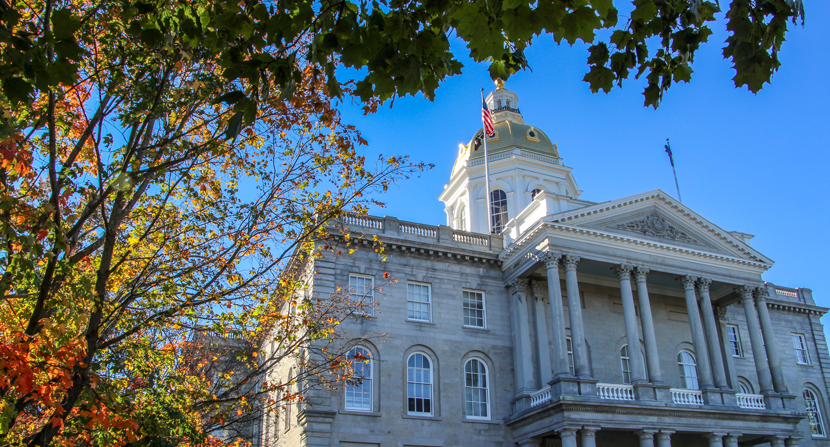 New Hampshire State House surrounded by trees and fall foliage in autumn