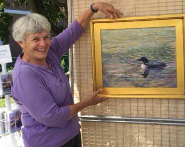 Mimi Wiggin poses with one of her paintings.