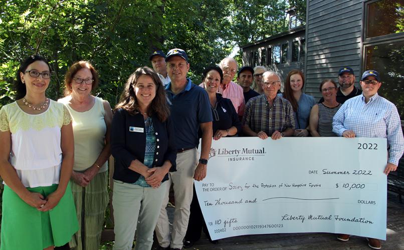 Representatives of the Forest Society and Liberty Mutual pose with a giant check. (Photo: Anna Berry)