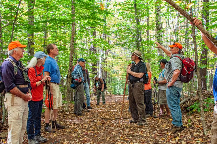 Dave Anderson talks to a group of volunteers in the woods at Hay Reservation