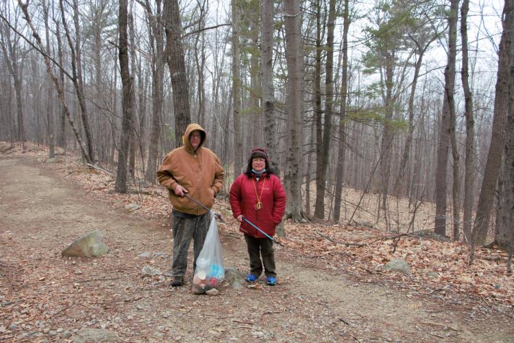 Parents hold a trash bag along the trail at Mount Major.