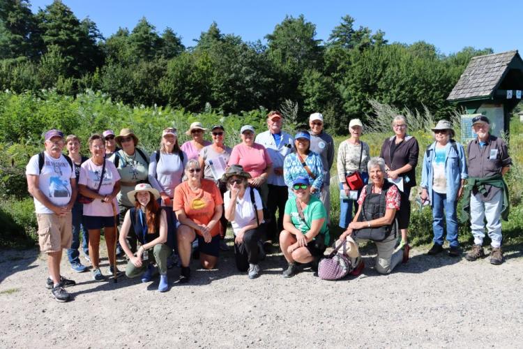 colorful hiking group poses for parking lot selfie in Rochester