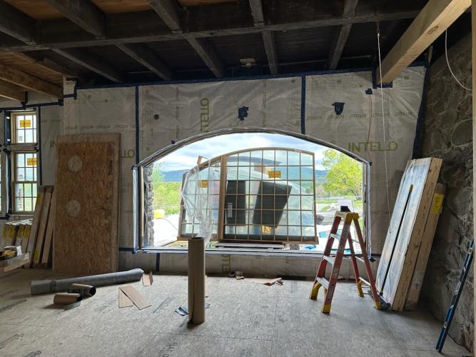 A large window is loaded into the space that used to serve as the arched gate of the barn.