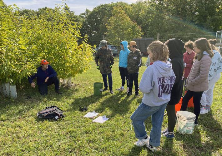 Field Forester Gabe Roxby helps the students understand the research ongoing at the orchard.