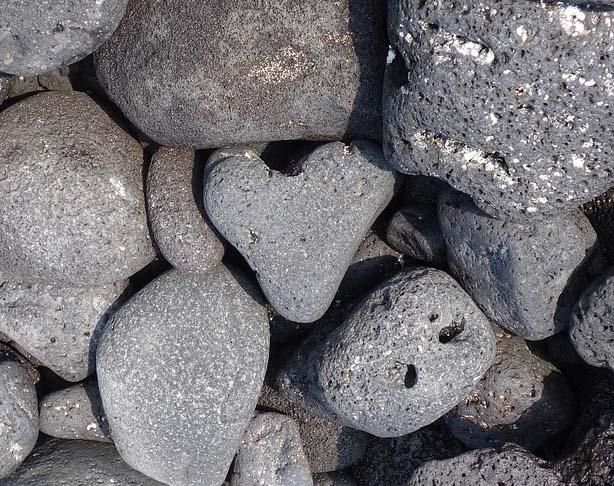 A heart-shaped rock sits in the middle of a rock pile.