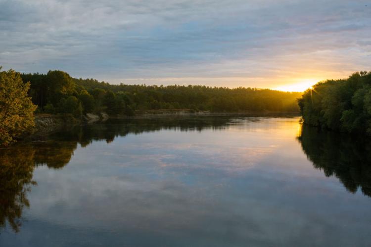 The sun sets over the Merrimack River near the Forest Society's conservation area.