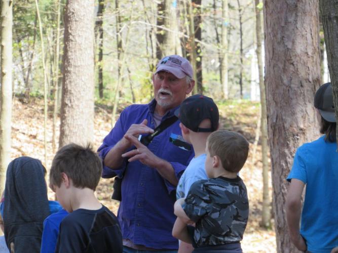 Naturalist in  purple shirt shares story with local students